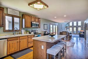 eine Küche mit Holzschränken und eine Kücheninsel mit Barhockern in der Unterkunft Apple Valley Home, Shared Golf Course On-Site in Mount Vernon