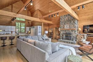 una sala de estar con sofás y una chimenea de piedra. en Elegant and Quiet Maine Escape with Sauna and Deck!, en Harrison