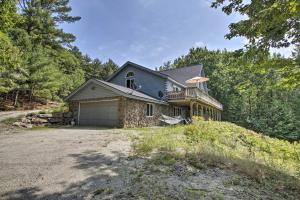 a house with a garage on a hill at Elegant and Quiet Maine Escape with Sauna and Deck! in Harrison
