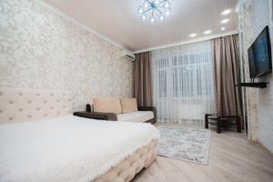 マイコープにあるApartment Sovetskaya 184のベッドルーム(ベッド1台、ソファ、テレビ付)