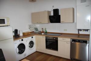 a kitchen with a washing machine and a washer and dryer at Gemütliche City Wohnung - Im Herzen von Trier in Trier
