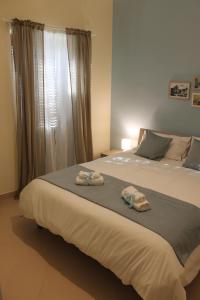 1 dormitorio con 1 cama grande y toallas. en Casa Lamberti B&B, en Cava deʼ Tirreni