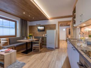 a kitchen and living room with a table and a refrigerator at Ferienwohnung Garber in Zell am Ziller