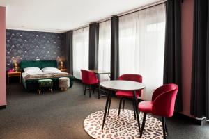 1 dormitorio con 1 cama, mesa y sillas en SmartHotel Flamingo Self check-in en Gießen