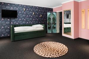 a bedroom with a bed and a tv and a rug at SmartHotel Flamingo Self check-in in Gießen