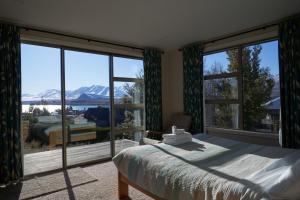 a bedroom with a bed and a view of a mountain at Takapō Escape - Lake Tekapo in Lake Tekapo