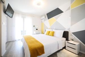 una camera da letto con un grande letto bianco con una coperta gialla di Villa Tia with heated pool a Murvica