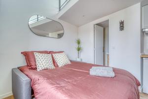 a bedroom with a large bed with a pink blanket at Studio mezzanine 3-4 pers tout équipé WIFI in Montreuil