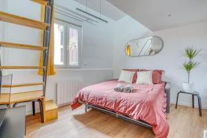 a bedroom with a bed with a pink bedspread at Studio mezzanine 3-4 pers tout équipé WIFI in Montreuil