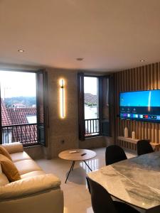 ein Wohnzimmer mit einem Sofa und einem TV in der Unterkunft Luxury Apartment with Jacuzzi in Santiago de Compostela