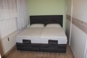 a bed in a small room with a black bed frame at Apartman BKK in Bad Kleinkirchheim
