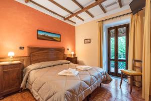 - une chambre avec un grand lit aux murs orange dans l'établissement Casale dei Gelsi, à Castiglione in Teverina