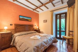 Castiglione in TeverinaにあるCasale dei Gelsiのベッドルーム1室(オレンジ色の壁の大型ベッド1台付)