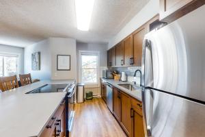 a kitchen with stainless steel appliances and wooden cabinets at Sawmill Creek 216 in Breckenridge +19 photos