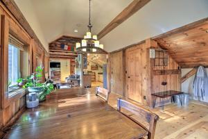 a living room with wooden walls and a table and benches at Cambridge Cabin Less Than 2 Mi to Smugglers Notch! in Jeffersonville