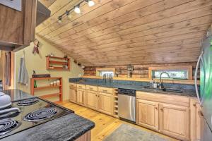 a kitchen with wooden walls and a wooden ceiling at Cambridge Cabin Less Than 2 Mi to Smugglers Notch! in Jeffersonville