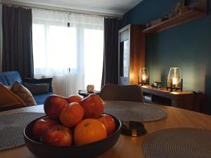 uma taça de fruta numa mesa numa sala de estar em MD Apartament Lewandowskiego em Szczecin