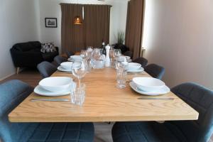 uma longa mesa de madeira com pratos e copos de vinho em Efri Bru em Selfoss