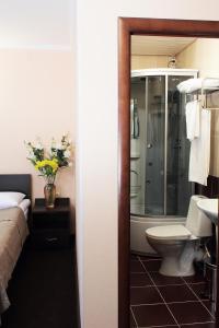 a bathroom with a shower and a toilet and a sink at Kristall Hotel in Surgut
