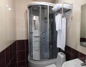 y baño con ducha, aseo y lavamanos. en Kristall Hotel, en Surgut
