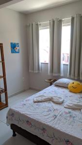 a bedroom with a bed with a yellow pillow on it at Apartamento aconchegante 2 quartos com suíte na praia de Guaibim in Guaibim