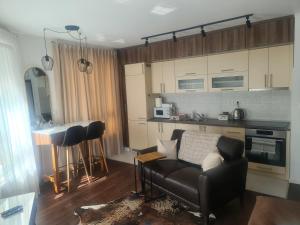 a living room with a couch and a kitchen at Tuzla Trg - Tuzla Square in Tuzla