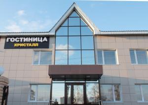 a building with a sign on the front of it at Kristall Hotel in Surgut