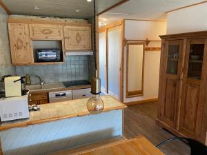 a kitchen with wooden cabinets and a counter top at MyHome - Moutières B2 17 - Grand 2 pièces traversant au Val Claret, 4 à 6 pers in Tignes