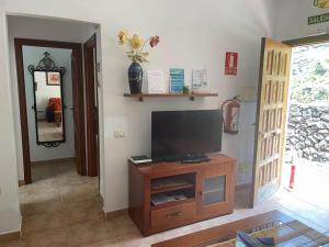 sala de estar con TV en un armario de madera en El Hoyo, en La Frontera