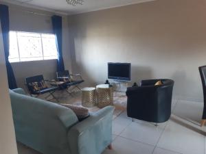 a living room with two couches and a television at Halina's Apartment in Lusaka