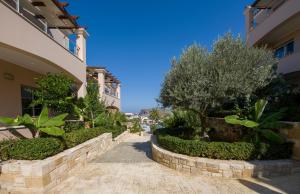 a street in a villa with trees and bushes at Isida Hotel Agia Marina in Agia Marina Nea Kydonias