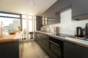 uma cozinha com electrodomésticos de aço inoxidável e uma grande janela em * PANORAMIC PENTHOUSE WITH SEA & CITY VIEWS em Bournemouth