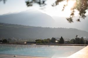 a large swimming pool with a mountain in the background at Hotel Das Dorner in Lagundo