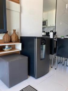 uma cozinha com um frigorífico, uma mesa e cadeiras em Porto Real Suites Resort em Mangaratiba