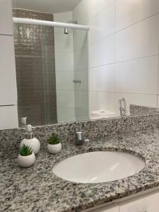 um balcão de casa de banho com um lavatório e um espelho em Porto Real Suites Resort em Mangaratiba