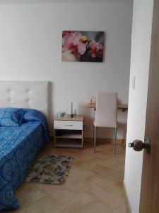 a bedroom with a bed and a desk and a table at Habitación Privada in Ibagué