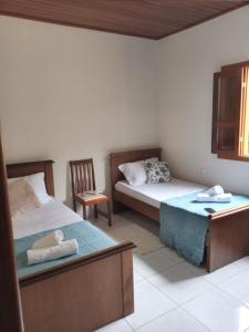 Säng eller sängar i ett rum på Passarinhada Hospedagem