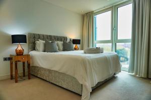 a bedroom with a large bed with a large window at GWQ Apartments Luxe in Portsmouth