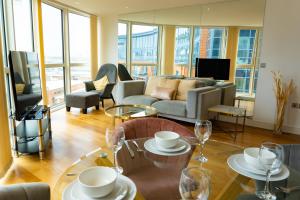 uma sala de estar com um sofá e uma mesa com copos de vinho em GWQ Apartments Luxe em Portsmouth