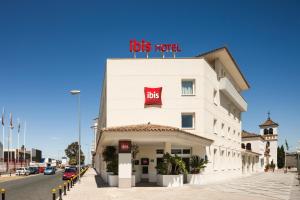 a large building with a sign on the side of it at Ibis Sevilla in Seville
