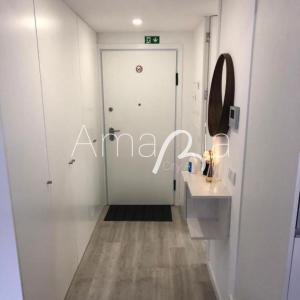 Baño blanco con lavabo y espejo en AmaRiaCity AL en Aveiro