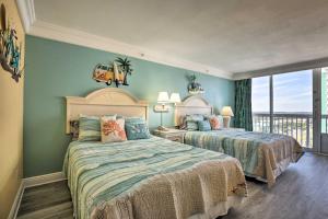 2 Betten in einem Schlafzimmer mit blauen Wänden in der Unterkunft Ocean-View Daytona Beach Resort Retreat with Balcony in Daytona Beach