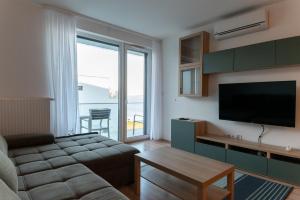 a living room with a couch and a flat screen tv at Balatoni Apartman in Fonyód