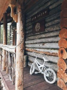 a bike parked on the porch of a log cabin at Guesthouse Husky Moa in Poselok-Matrosy