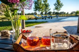 a table with two glasses and a vase of flowers at Estancia La Sofia in San Andrés de Giles