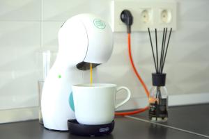 een koffiezetapparaat dat koffie giet in een kopje op een aanrecht bij Luxury Senator Apartments in Costa Teguise