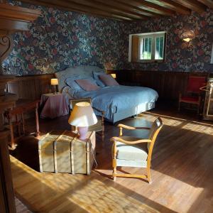 a bedroom with a bed and a chair at Suite au château - Domaine de la Gavolerie in Bessé-sur-Braye