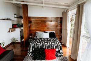 a bedroom with a bed with black and red pillows at Glamping Casa Viva in Pereira