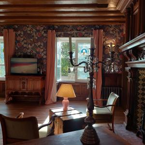 a living room with a table and a lamp and a window at Suite au château - Domaine de la Gavolerie in Bessé-sur-Braye