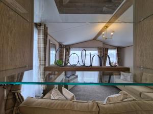uma sala de estar com um sofá e uma mesa em Stunning Platinum Caravan in Rhyl 2 mins to Beach em Rhyl